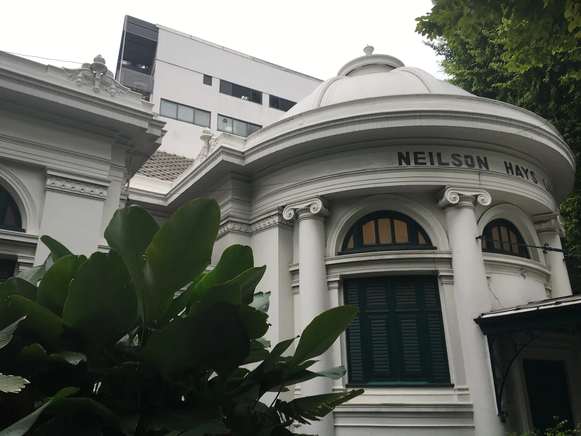 The curved white front of the Neilson Hays Library with its lettering and arched windows