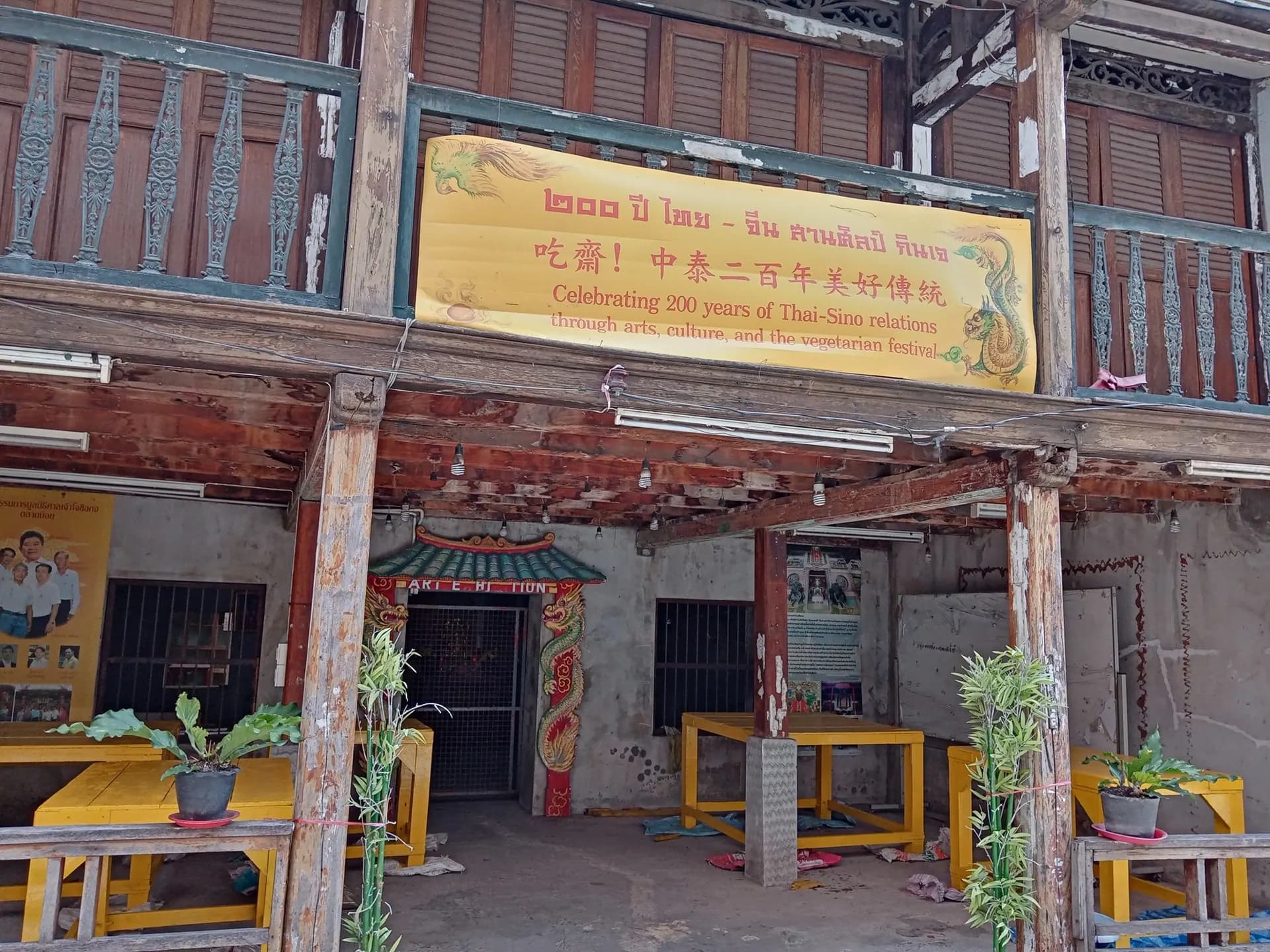 An old timber house in Talat Noi with a banner marking two hundred years