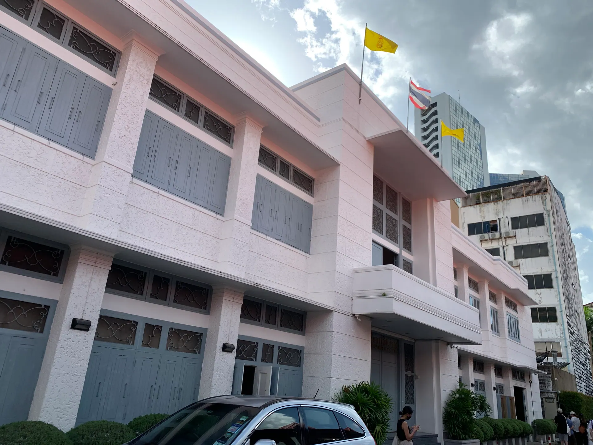 The pale rendered front of a Warehouse 30 building with flags on its roof