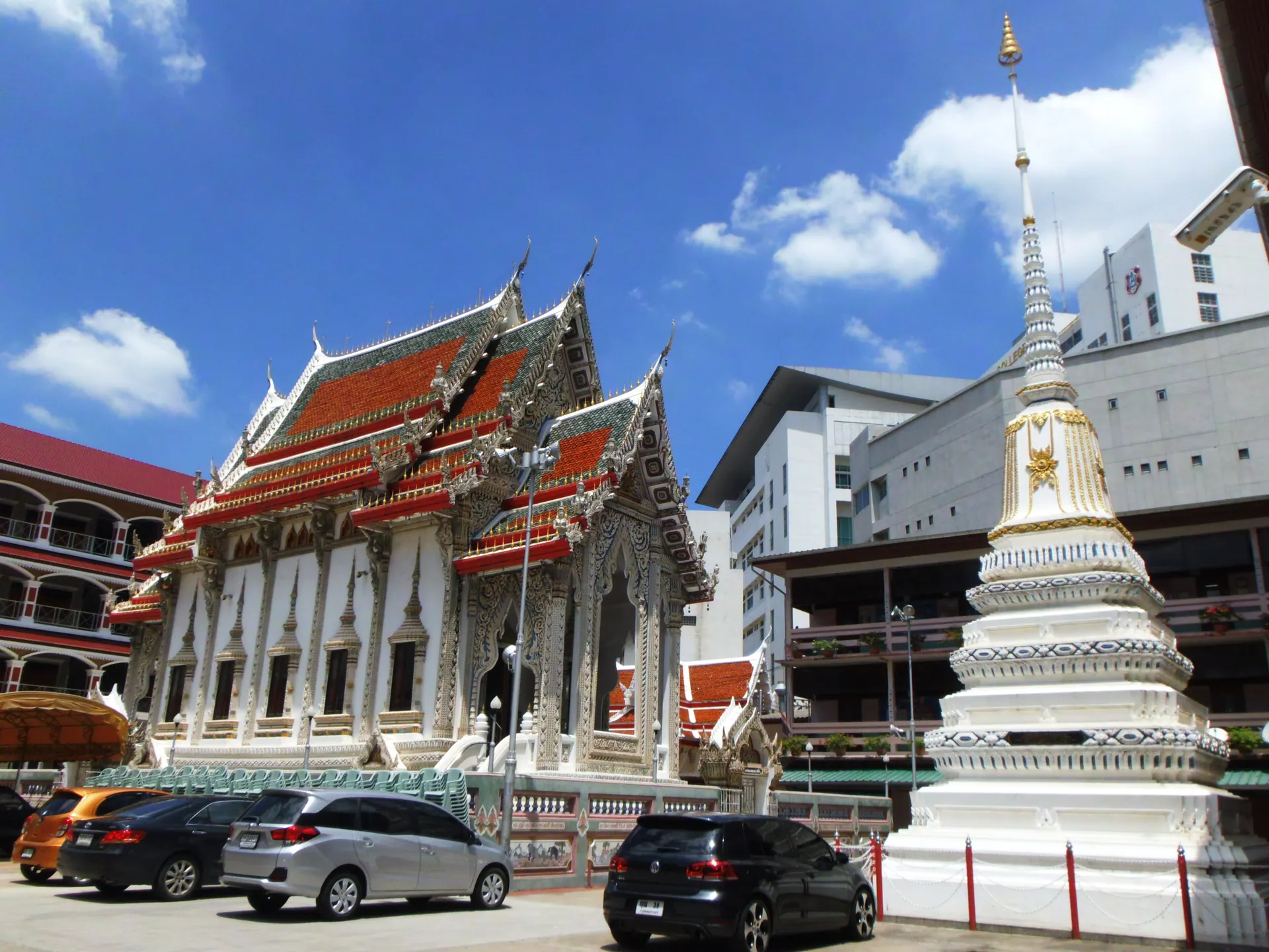 The ordination hall and a white chedi at Wat Suan Phlu under a blue sky